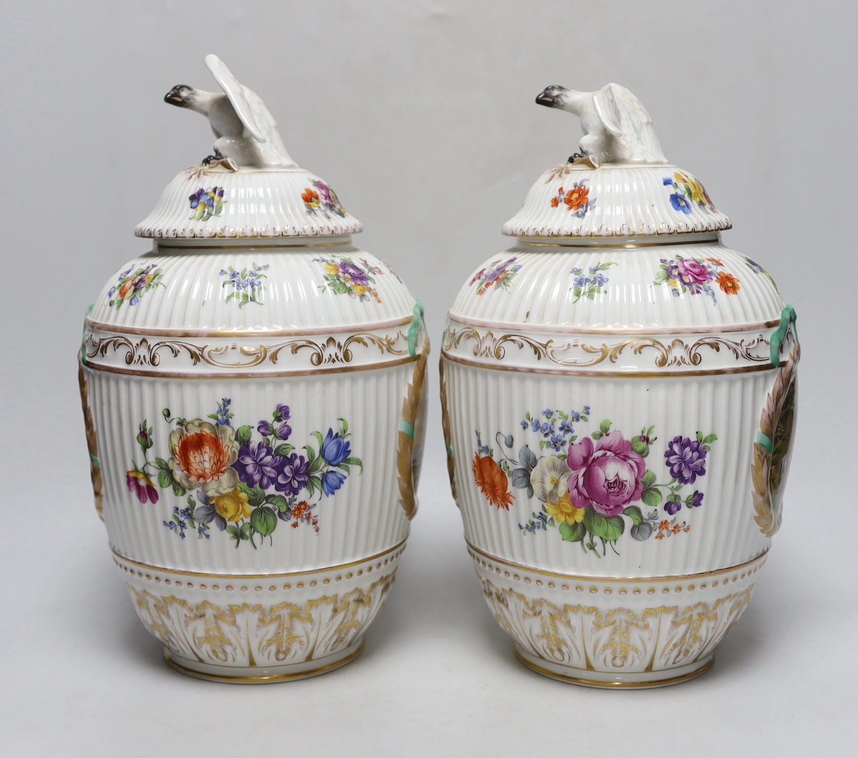 Two Dresden porcelain vases with bird decoration finials, and central horse scenes display, 30cm tall